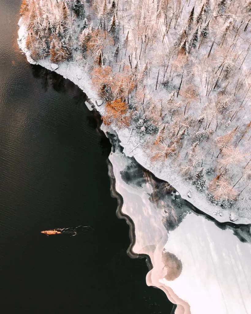 Photo par drone d'un canoë au Parc du Poisson Blanc lors du tournage avec Martin Trahan, un aventurier canadien.