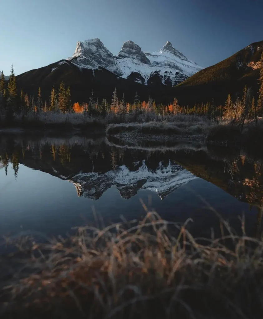 Photo de paysage en réflexion des pics des Three Sisters à Canmore (Alberta)